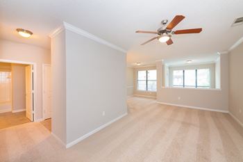 A room with a ceiling fan and carpeted floor.